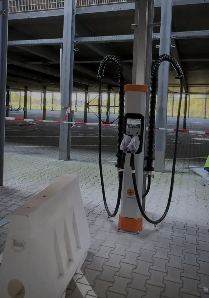 Ladesäule mit aufgehängten Ladekabeln unter dem Parkdeck