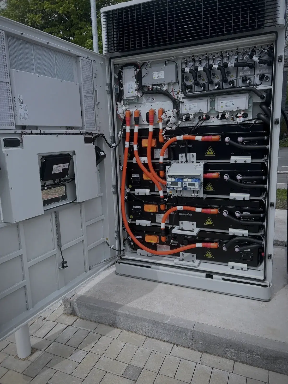 Geöffneter Anschlussschrank mit orangefarbenen Leistungsleitungen und Messtechnik